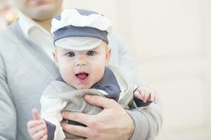 alegre juguetón bebé en su del padre brazos. bebé y papá foto