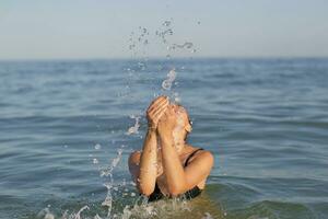 mujer en el mar con salpicaduras de agua. foto