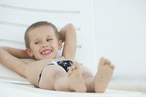 A child in a lounge chair by the sea. Little boy resting on the sea photo