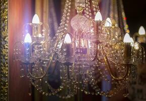 Part of an antique luxury pendant lamp with sparkling beads illuminated by light. photo