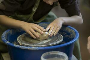 Potter's hands at work. Close-up of a potter's hands with a product on a potter's wheel. Working with clay. photo