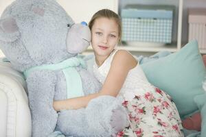 linda pequeño niña con un enorme osito de peluche oso.hermoso adolescente con un suave juguete foto