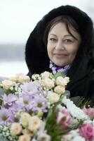 Middle-aged woman with a bouquet of flowers photo