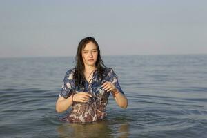 Beautiful young girl in the sea.Woman stands in the water photo
