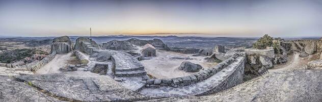 Panoramic image of the fortification above the historic town of Monsanto in Portugal during sunrise photo