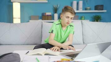 a Garoto olhando às a computador enquanto estudando é chateado. video