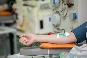 de cerca de un mujer mano mientras donando sangre a un sangre donación centro. foto