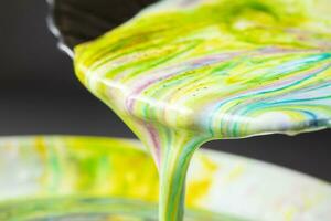 Acrylic paint pours from the plate. Creativity process. photo
