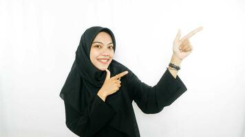 young asian woman using finger pointing in different directions with blank copy space standing over isolated white background. Pointing finger. Giving directions photo