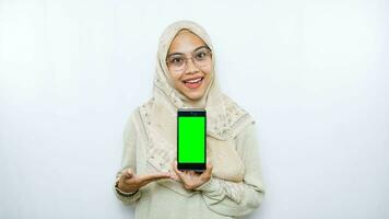 young asian woman showing copy space on her phone screen. Isolated over white background photo