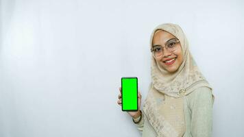 young asian woman showing copy space on her phone screen. Isolated over white background photo