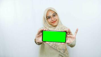 young asian woman showing copy space on her phone screen. Isolated over white background photo