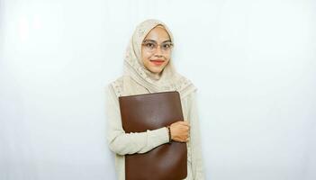 young asian woman holding a folder and smiling at the camera photo