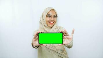 young asian woman showing copy space on her phone screen. Isolated over white background photo