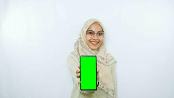 young asian woman showing copy space on her phone screen. Isolated over white background photo