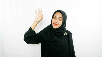 young asian woman using finger pointing in different directions with blank copy space standing over isolated white background. Pointing finger. Giving directions photo