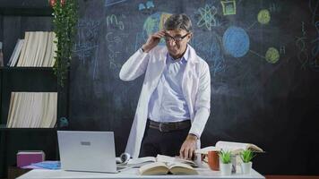 The scientist looks around at his desk thoughtfully. video