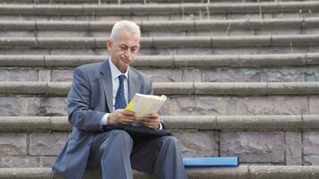 Bored of work Businessman sitting outdoors in the park. video