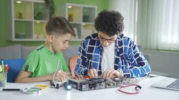 Two brothers are trying to fix the technological device. video