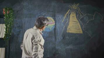 Masculin professeur dessin volcan sur tableau noir. video