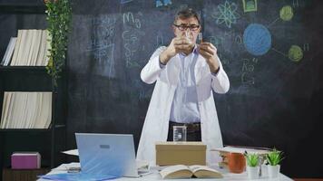 Scientist conducts experiments by looking at the element table. video