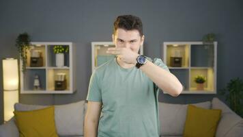 Man looking at camera cuts by making scissors sign. video