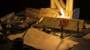 queimando luz de velas e velho papiro papel dentro antigo vezes. video