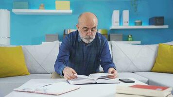 Thoughtful old man reading a book. video