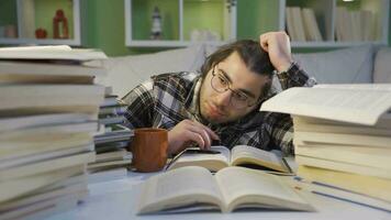 el cansado joven hombre es cansado de mirando a el libros. video