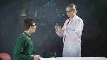 The teacher has her student do a chemistry experiment. video