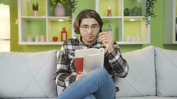 joven hombre leyendo emocional novela se convierte triste. video