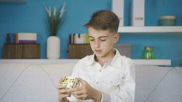 Skillful boy doing the brain teaser at home. video