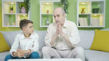 Grandfather praying with his grandson. video