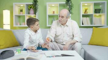 Grandpa helping his grandson with his homework. video