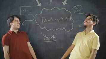 Young man writing Alcohol use on blackboard. video