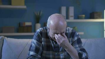 Worried old man sitting alone at home and crying. video