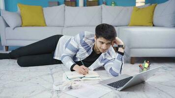 Cheerful young man studying relaxed at home lying down. video