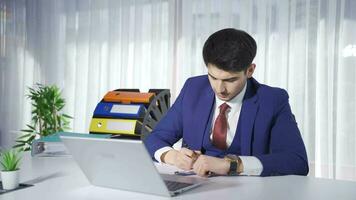 Successful young businessman working in office looking at camera. video