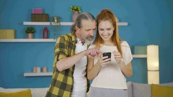 padre e figlia piace il nuovo App su il Telefono. video