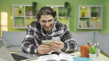 le Masculin étudiant qui gagne argent est content et joyeux. video