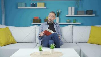 Man reading book is thoughtful and happy. video