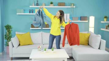 Young girl trying to choose clothes by dancing. video