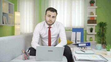 Young businessman working at home looking at camera. video