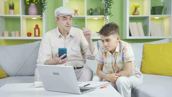 The grandfather, who has poor eyesight, does not use the phone and his grandson helps him. video