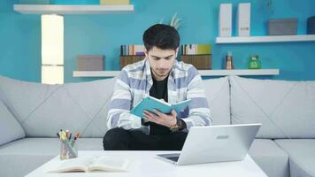 infeliz y aburrido joven hombre estudiando a hogar. video