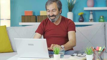 Middle-aged man happy with what he sees on the computer. video