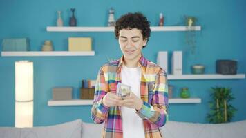 Cheerful and happy adolescent boy counting money. video