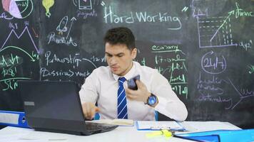 Businessman diligently writes on blackboard and binds arm. video