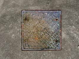 Rusted manhole cover, grunge style manhole cover, square edge, photo