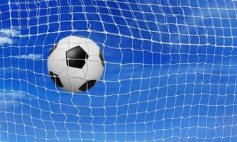 The soccer ball goes into the net and scores a goal. sky background photo